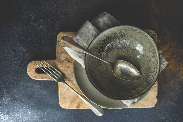 Apparecchiatura tavolo rustico con piatto vuoto e posate impostato su sfondo di cemento con spazio copia - Foto, immagini
