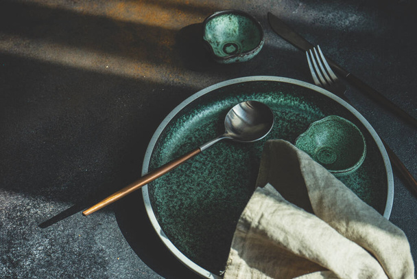 Rustikale Tischdekoration mit leerem Teller und Besteck auf Betongrund mit Kopierraum - Foto, Bild