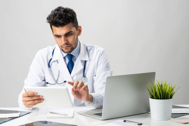Young arab internist working with tablet computer - 写真・画像