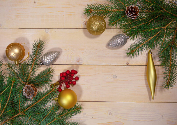 Spruce branches with Christmas decorations on a wooden background. Space for text. The view from the top - Photo, Image