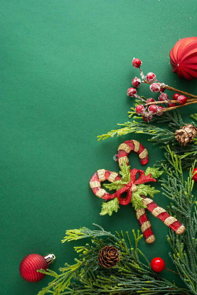 Christmas green background with winter decorations, gift boxes, fir branches, pine cones and red baubles. Copy space. - Foto, afbeelding