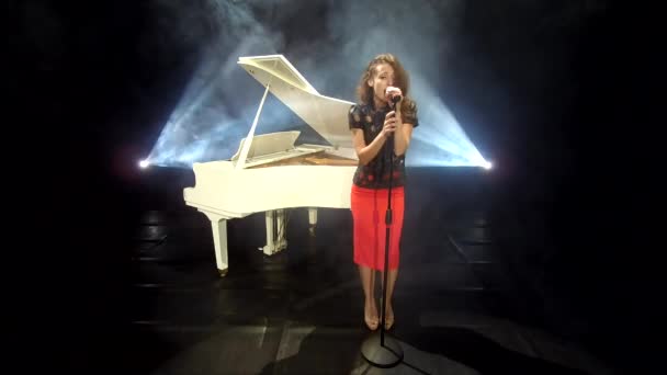 chanteuse rétro chantant du jazz au microphone sur scène avec projecteurs et piano blanc, musique. - Séquence, vidéo