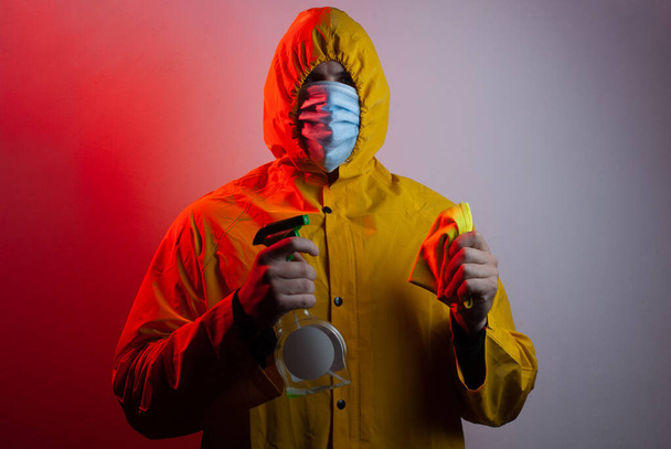 Een man in pak en medisch masker desinfecteert de kamer., - Foto, afbeelding