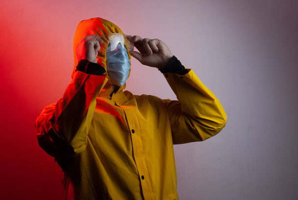Ein Arzt im gelben Anzug mit Kapuze und Schutzbrille betrachtet die Messwerte, - Foto, Bild
