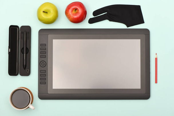 Γραφική οθόνη γραφίδα και γάντι σε πίνακα χρώματος lime. Μαύρο tablet υπολογιστή με κενή οθόνη. Φωτογραφία υψηλής ανάλυσης. Πλήρες βάθος πεδίου. Έννοια περιβάλλοντος εργασίας - Φωτογραφία, εικόνα