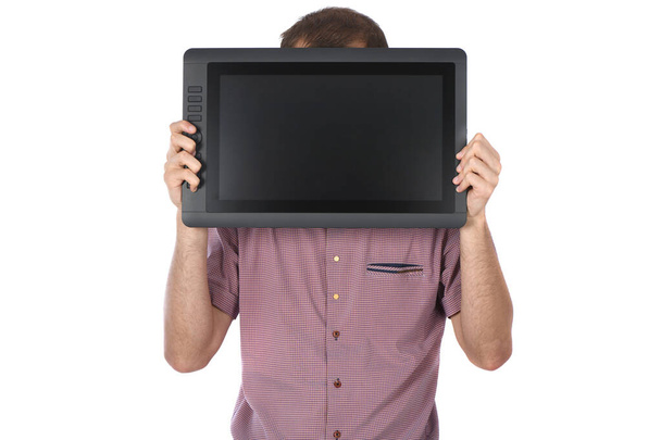 Muž drží grafický monitor na bílém pozadí. Černý tablet s prázdnou obrazovkou. Fotka ve vysokém rozlišení. Plná hloubka pole. - Fotografie, Obrázek