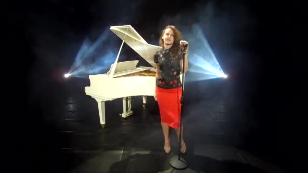 retro girl singer cantando jazz em microfone no palco com holofotes e piano branco, música. - Filmagem, Vídeo