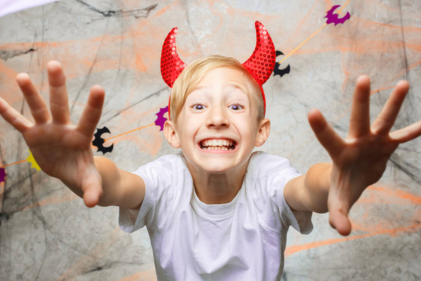 dziecko pokazuje śmieszne twarze do kamery w Halloween - Zdjęcie, obraz