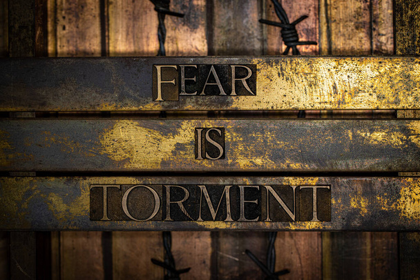 Fear is Torment text message on textured grunge copper and vintage gold background with barbed wire - Photo, Image