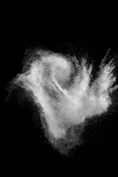 Άσπρο σύννεφο έκρηξης σκόνης ενάντια στο μαύρο φόντο.Λευκά σωματίδια σκόνης πιτσιλίζουν. - Φωτογραφία, εικόνα