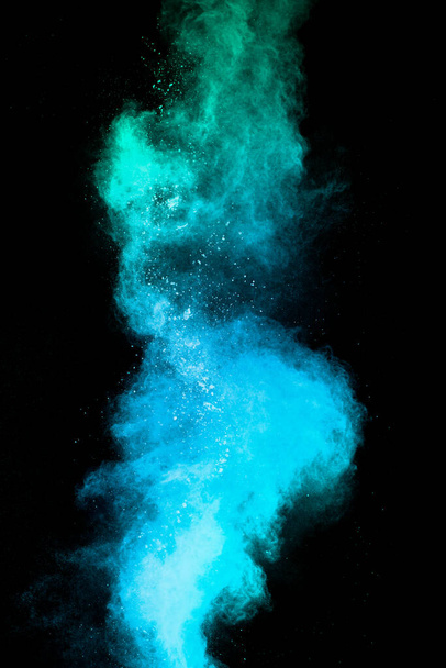 Launched blue dust particles splashing.Bizarre forms of blue powder explosion cloud on white background. - Photo, Image
