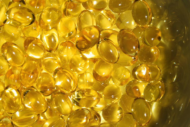 Dużo żółtych kapsułek, złoty olej ryba omega 3 kapsułki - Omega-3 stosy oleju na białym backgounf. Olej rybny. - Zdjęcie, obraz