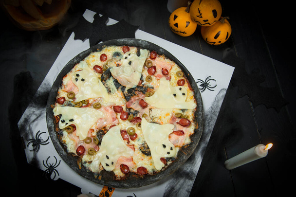Ακριβώς πάνω από την άποψη του Halloween κόμμα πίτσα φάντασμα σερβίρεται στο κουτί παράδοσης. Νυχτερίδες, αράχνες, κεριά και ζωγραφισμένες κολοκύθες σε μαύρο πίνακα. Ιστός αράχνης σε κουτί πίτσας. Φρίκη δημιουργική έννοια των τροφίμων - Φωτογραφία, εικόνα