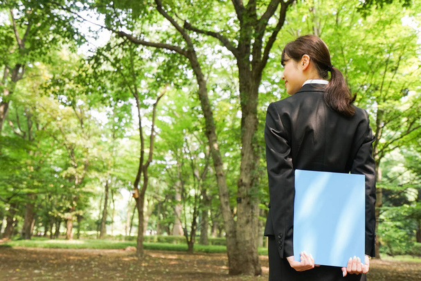 young business woman with blue documents folder outdoors - Fotó, kép