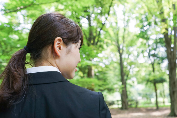 Молодая деловая женщина позирует в зеленом парке - Фото, изображение