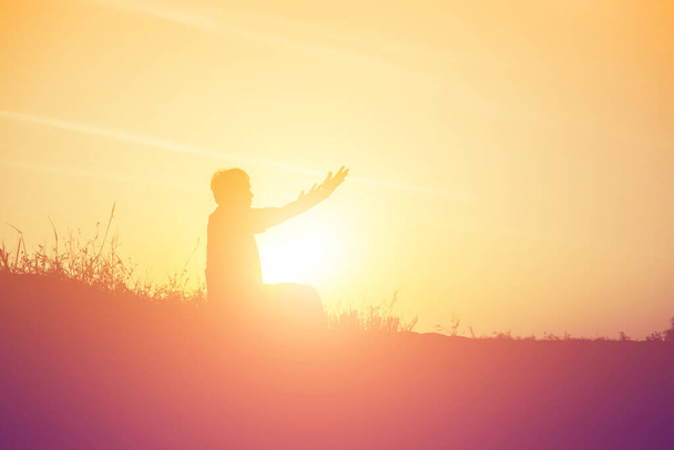 Silhouette di donna che prega su uno sfondo bellissimo cielo - Foto, immagini