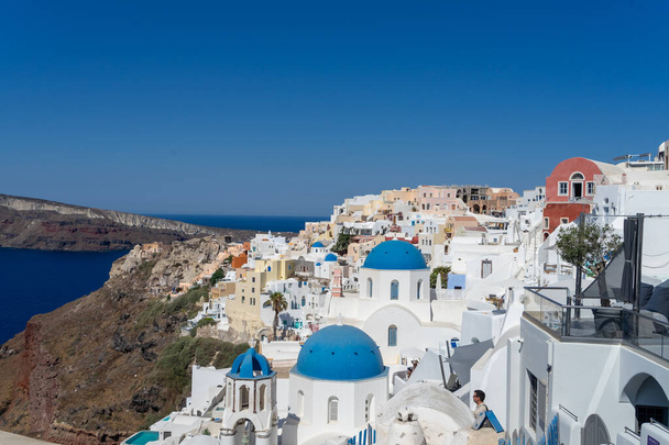 View of Santorini, with typical blue dome church, old whitewashed houses and caldera. Greek landscape on a sunny day - Foto, Imagem
