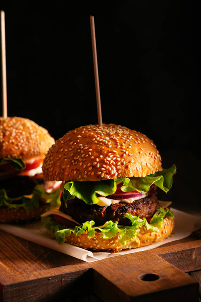 Two burgers on a wooden board - Foto, imagen