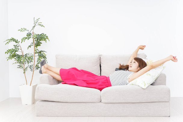Jeune asiatique femme dormir sur canapé - Photo, image