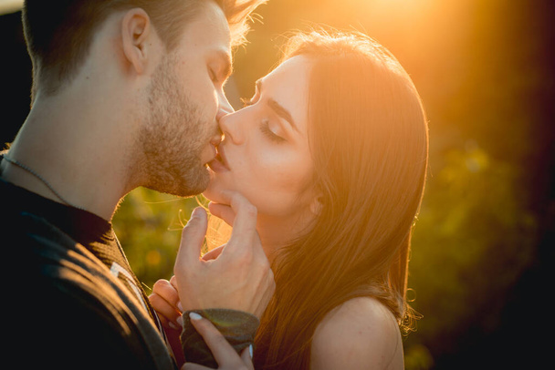 Kissing couple in love. Sexy lovers kiss outdoor at sunset. Sensual Young people. - Photo, image