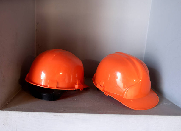 giubbotti di lavoro gialli sono appesi a un appendiabiti. Cappelli rigidi e giubbotti di sicurezza sul gancio. - Foto, immagini
