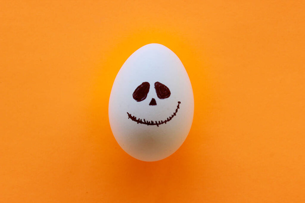 Halloween ghost egg isolated on orange background, Halloween concept - Photo, Image