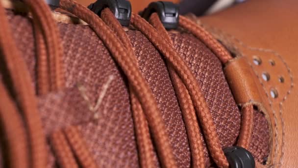 Closeup of rotating pair of fashionable weatherproof leather rufous boots with laces. Extreme sport shoes, youth fashion concept. - Footage, Video