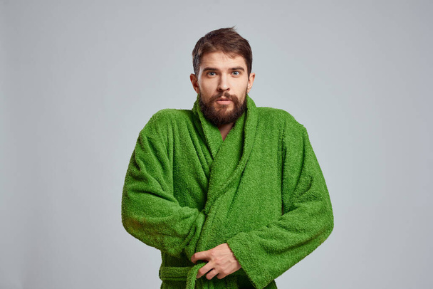 Close-up view of a bearded man in a green robe on a light background cropped view - Foto, afbeelding