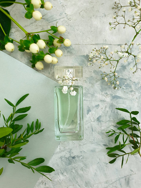 botella perfume flor sobre un fondo concreto - Foto, imagen