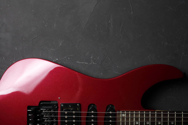 暗いコンクリートの背景に赤いエレクトリックギター、あなたのテキストのための場所。上からの眺め. - 写真・画像