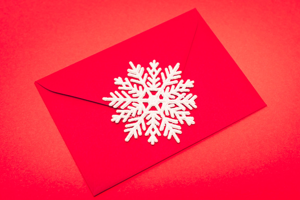 top view of snowflake and envelope on red background - Photo, Image