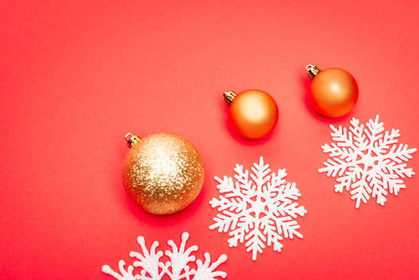 top view of snowflakes, baubles on red background - Photo, Image