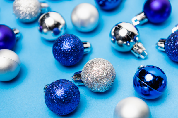 shiny Christmas baubles on blue background - Foto, Imagen