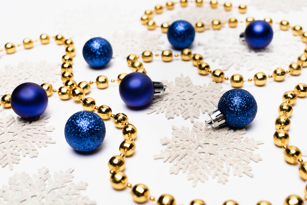 decoración navideña azul, plateada y dorada con copos de nieve sobre fondo blanco - Foto, Imagen