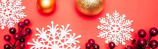 top view of baubles, snowflakes and berries on red background, banner - Photo, Image