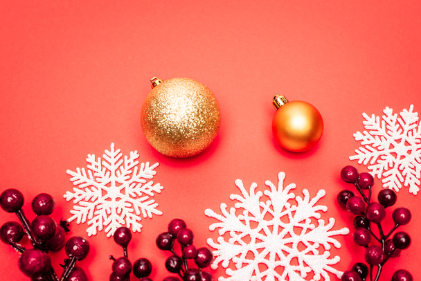 top view of baubles, snowflakes and berries on red background - Фото, зображення