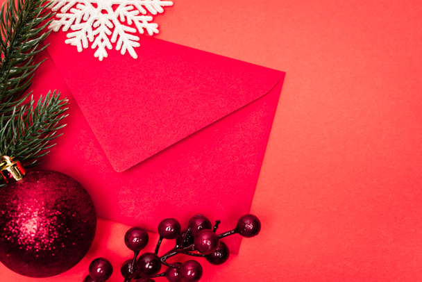 вид зверху на різдвяну прикрасу та конверт на червоному тлі
 - Фото, зображення