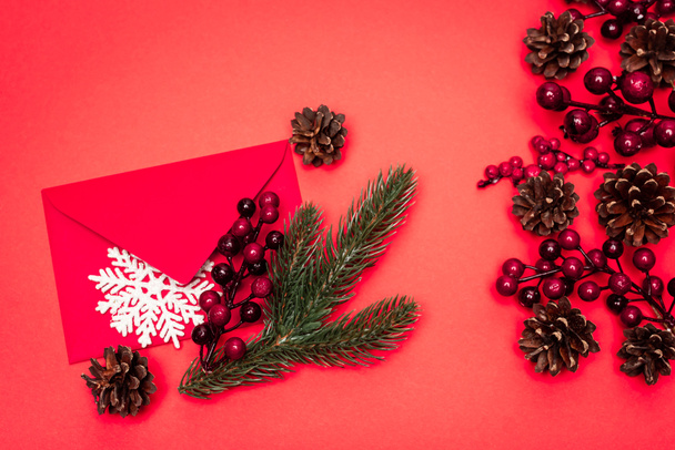 top view of Christmas decoration and envelope on red background - Фото, зображення