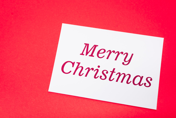 top view of white merry Christmas card on red background - Φωτογραφία, εικόνα