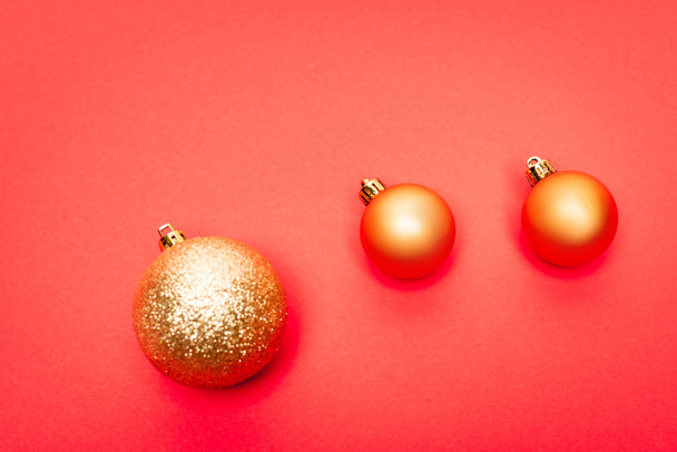 top view of shiny baubles on red background - Fotoğraf, Görsel