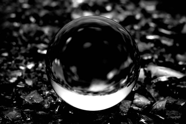 Sumea kuva läpinäkyvästä kristallipallosta. Musta ja valkoinen kuva objektiivi pallo abstrakti hämärä. - Valokuva, kuva