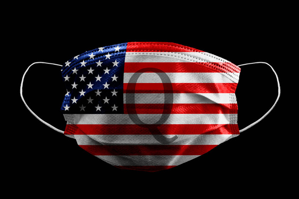 Текст тайного государственного заговора Канона на медицинской хирургической маске Американский флаг изолирован на черном - Фото, изображение