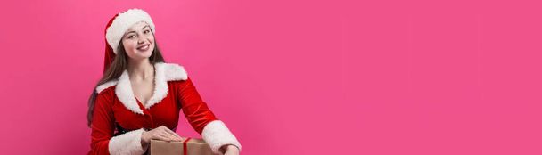 Beautiful young woman in Santa Claus costume against the red background. - Foto, immagini
