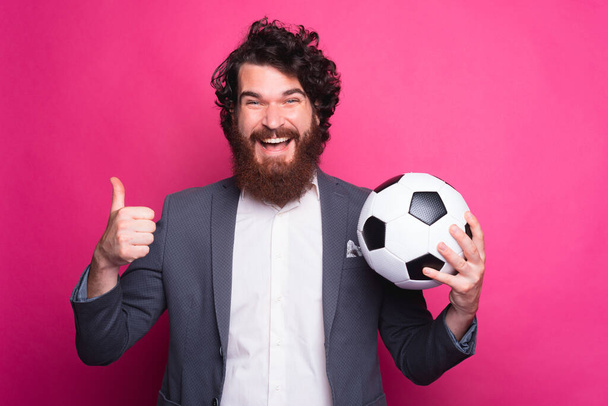 私のチームは最高です,親指を表示し、サッカーボールを保持スーツでアメイジング髭の男 - 写真・画像