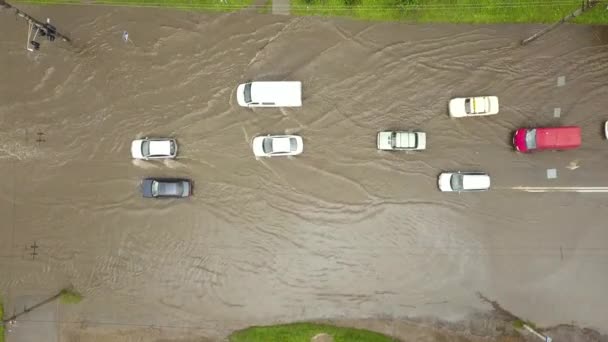 Вид с воздуха на транспортные средства, движущиеся по затопленной дороге с дождевой водой. - Кадры, видео
