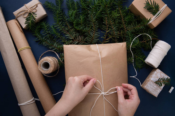  手はクリスマスプレゼントとバッグの上に文字列を結ぶ - 写真・画像