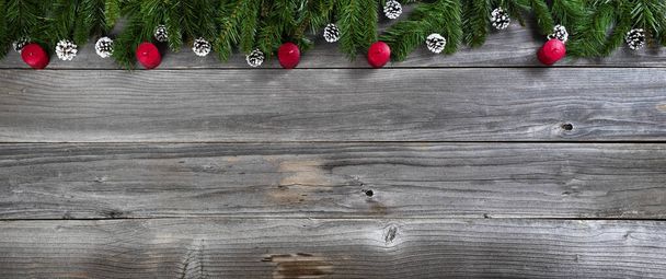素朴な木の板の上にモミの枝の中に赤いキャンドルとメリークリスマスと幸せな新年のコンセプト  - 写真・画像