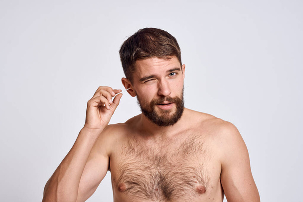Bearded man with bare shoulders cotton swabs hygiene body care - Photo, Image