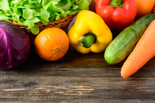 Verduras frescas coloridas en la mesa de madera (col, lechuga, pimiento, pepino, zanahoria y naranja)) - Foto, imagen