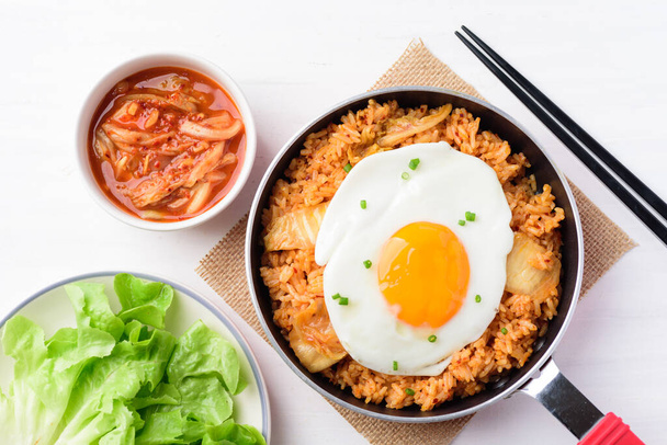 Comida coreana, Kimchi arroz frito com ovo frito em pequena panela de cozinhar na mesa branca, Vista superior - Foto, Imagem